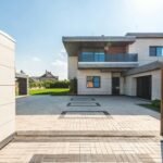 Contemporary two-story luxury home with spacious paved driveway and garden.